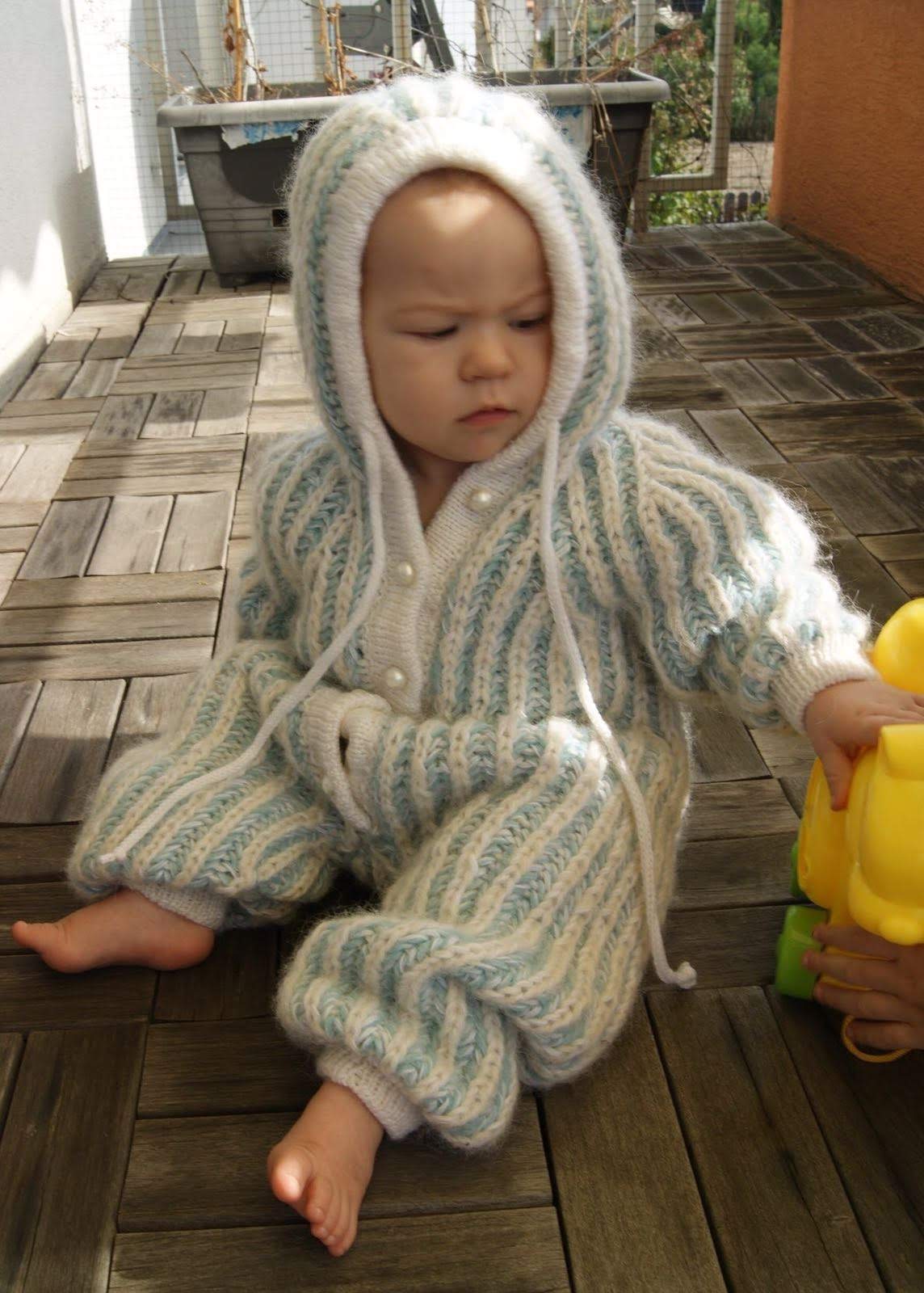 Baby knitting romper with hood and raglan sleeves